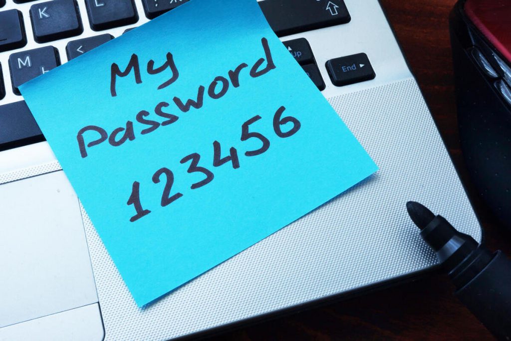 A stock image of a password written on a sticky note that's left out in the open on a laptop