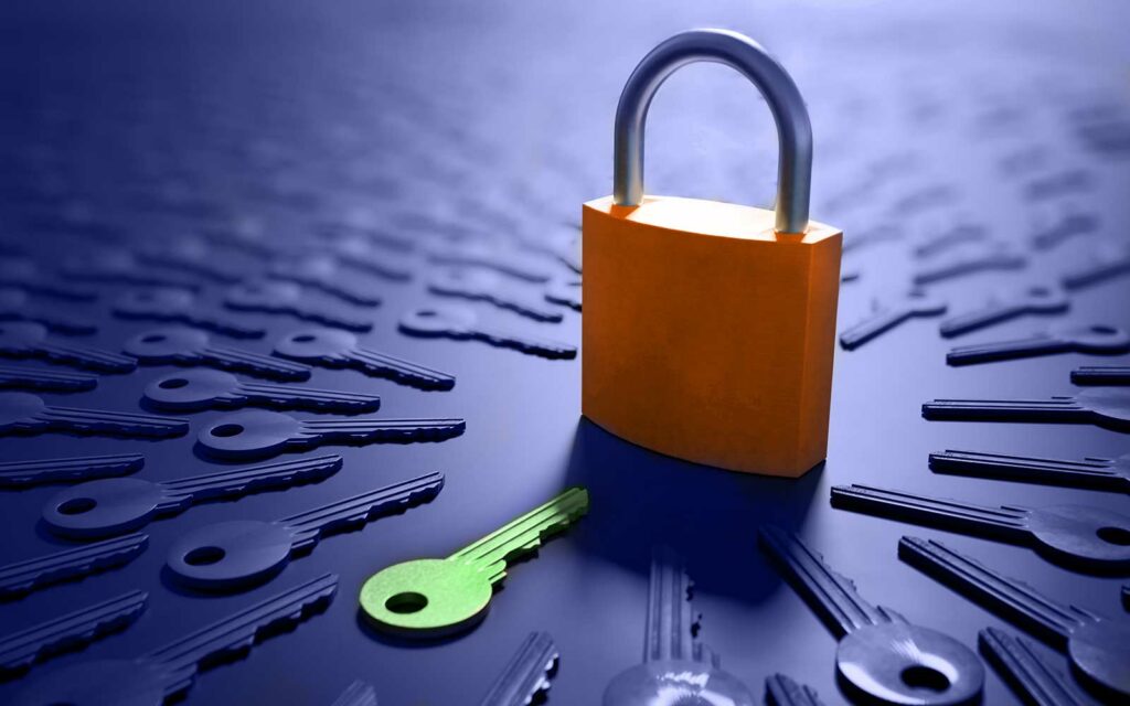 A stock image featuring a secure orange padlock surrounded by generic keys and a single green brightly colored key that stands out from the rest.